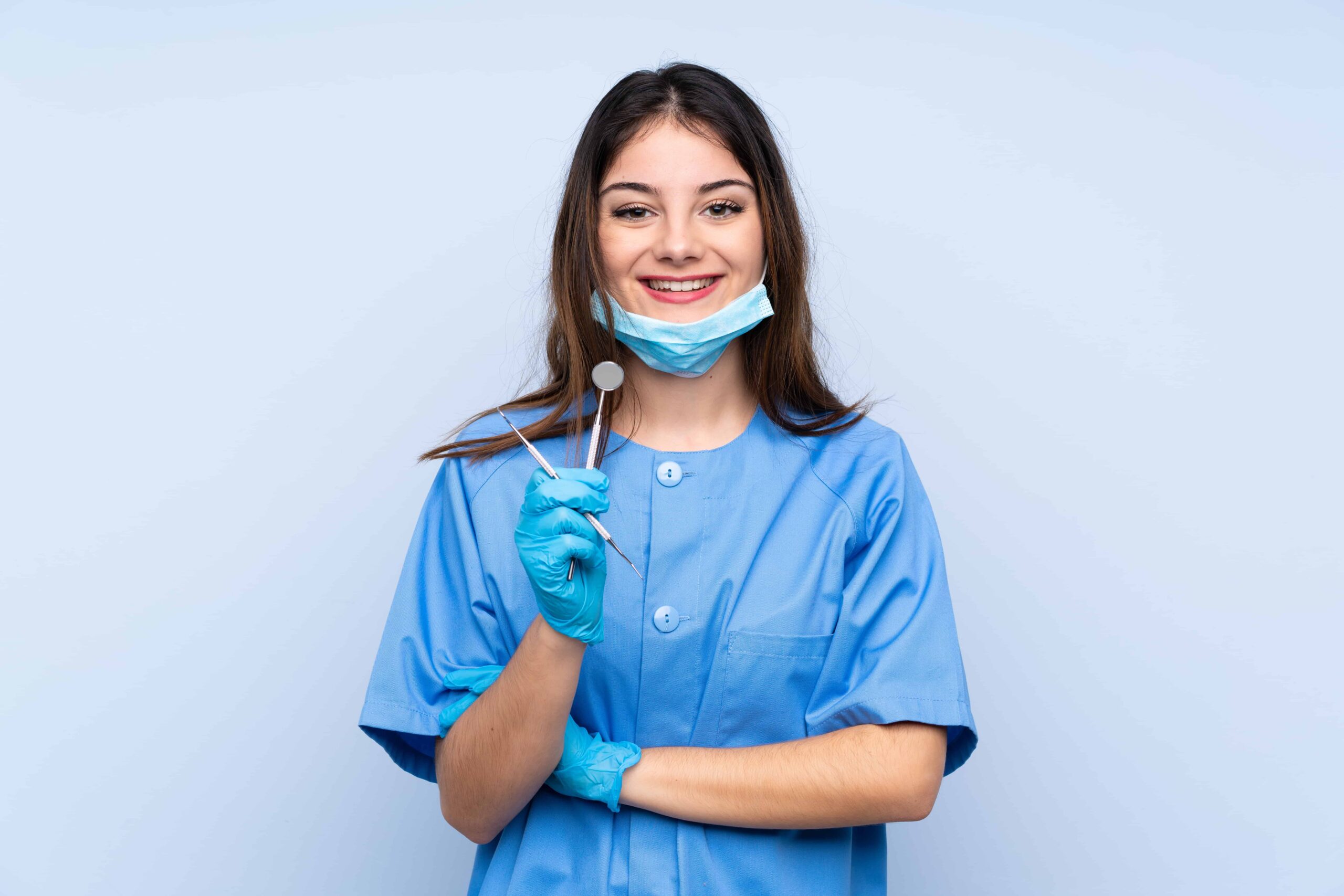 woman dentist holding tools laughing min